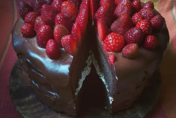 Dark chocolate and strawberry celebration cake, with a nougat layer in the middle